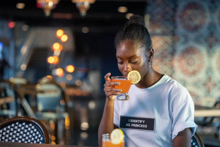 Craft Cocktails at Drive Shack - Drive Shack - Drive Shack Guest enjoying a citrus-garnished craft cocktail inside Drive Shack.